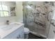 Stylish bathroom with a walk-in shower featuring decorative marble tile and a quartz countertop vanity at 5678 Fern Creek Sw Dr, Lilburn, GA 30047