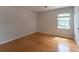 Bright bedroom with hardwood floors, neutral walls, and a large window providing ample natural light at 5678 Fern Creek Sw Dr, Lilburn, GA 30047