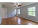 Bright bedroom featuring hardwood floors, two windows, and a ceiling fan at 5678 Fern Creek Sw Dr, Lilburn, GA 30047