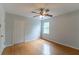 Cozy bedroom with hardwood floors, ceiling fan and window offering ample natural light at 5678 Fern Creek Sw Dr, Lilburn, GA 30047