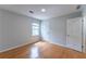 Bright bedroom featuring hardwood floors, a window providing natural light, and neutral-colored walls at 5678 Fern Creek Sw Dr, Lilburn, GA 30047