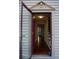 Inviting entryway featuring hardwood floors and decorative molding around an opened front door at 5678 Fern Creek Sw Dr, Lilburn, GA 30047