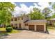 Classic two-story house featuring a two-car attached garage, red shutters, and a long driveway at 5678 Fern Creek Sw Dr, Lilburn, GA 30047