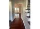 Inviting hallway with rich hardwood floors, leading to a bright living space with double doors at 5678 Fern Creek Sw Dr, Lilburn, GA 30047