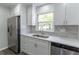 Updated kitchen showing cabinets, counter, faucet, sink, stainless appliances and gray vinyl plank flooring at 5678 Fern Creek Sw Dr, Lilburn, GA 30047