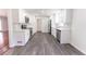 Newly renovated kitchen with stainless appliances, stone countertops, white cabinets, and gray vinyl plank flooring at 5678 Fern Creek Sw Dr, Lilburn, GA 30047