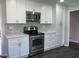 Modern kitchen featuring white cabinets, stainless steel appliances, and elegant countertops at 5678 Fern Creek Sw Dr, Lilburn, GA 30047