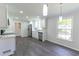 Bright kitchen with new stainless appliances, lighting, grey vinyl plank flooring and white cabinets at 5678 Fern Creek Sw Dr, Lilburn, GA 30047