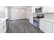 Updated kitchen featuring white cabinets, stainless steel appliances, and luxury vinyl plank flooring at 5678 Fern Creek Sw Dr, Lilburn, GA 30047