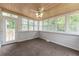 Bright sunroom with wood ceiling, multiple windows, neutral carpet, and access to the outdoor deck at 5678 Fern Creek Sw Dr, Lilburn, GA 30047