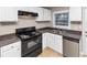 Updated kitchen with white cabinets, black appliances, and stainless steel dishwasher at 1834 Hillsdale Dr, Decatur, GA 30032