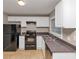 This kitchen includes white cabinetry, black appliances, and stone-look countertops at 1834 Hillsdale Dr, Decatur, GA 30032