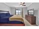 Well-lit main bedroom with a ceiling fan, window, dresser, and a comfortable bed at 305 Mill Pond Se Ct, Smyrna, GA 30082