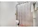 This bathroom shows a toilet and shower with patterned curtain and decorative fixtures and towel rack at 850 Third St, Stone Mountain, GA 30083