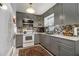 Bright kitchen showcases gray cabinetry, stainless steel microwave, and white appliances over an area rug at 850 Third St, Stone Mountain, GA 30083