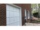 Attached garage with a white door on a brick home, featuring clean lines and a side window at 3320 Donegal Way, Snellville, GA 30039