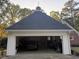 Exterior view of a two car garage with a weathervane and a black sports car inside at 3320 Donegal Way, Snellville, GA 30039