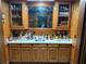 A home wet bar with dark wood cabinets, a sink, mirror, and storage at 3320 Donegal Way, Snellville, GA 30039