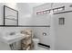 Bright bathroom features tiled walls, mosaic floors, updated fixtures, and decorative stained glass window at 1816 Williams Ave, East Point, GA 30344