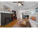 Charming living room with a decorative fireplace, built-in shelving, and seamless access to an open-concept kitchen at 1816 Williams Ave, East Point, GA 30344