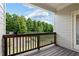 Relaxing balcony area with wood floors and railing overlooking mature trees and a landscaped lawn at 2289 Emerald Sky Dr, Smyrna, GA 30080
