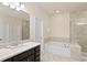 Bathroom featuring a white tub, a shower with glass doors, and a vanity with a dark cabinet at 2289 Emerald Sky Dr, Smyrna, GA 30080