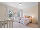 Bright bedroom featuring a crib, a changing table, neutral walls, and large windows at 2289 Emerald Sky Dr, Smyrna, GA 30080