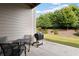 Cozy outdoor patio with a black dining set and grill, surrounded by mature trees and landscaping at 2289 Emerald Sky Dr, Smyrna, GA 30080