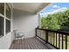 Relaxing porch with a gray chair and a wooden railing overlooking a lush, green view at 2289 Emerald Sky Dr, Smyrna, GA 30080