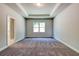 Bedroom featuring tray ceiling, carpeted floor, large window, and neutral paint at 258 Depot Landing Rd # 53, Auburn, GA 30011
