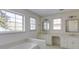 Bright bathroom featuring double sink vanity, large mirror, soaking tub, and ample natural light at 270 Grapevine Run, Sandy Springs, GA 30350