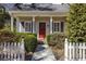 Home exterior with a white picket fence, a charming red door and manicured landscaping at 270 Grapevine Run, Sandy Springs, GA 30350