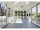 A screened-in porch with a gray floor and view of a wooded backyard at 270 Grapevine Run, Sandy Springs, GA 30350