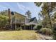 Rear view of a multi-story house with a screened porch and deck, nestled among mature trees and landscaping at 270 Grapevine Run, Sandy Springs, GA 30350