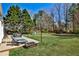 Spacious backyard with seating areas, play equipment, and mature trees at 705 Chanson Sw Dr, Marietta, GA 30064