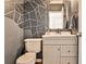 Stylish powder room with geometric accent wall, modern vanity, and gold-framed mirror, offering a chic and functional space at 705 Chanson Sw Dr, Marietta, GA 30064