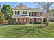 Charming two-story home with a brick facade, manicured lawn, and mature trees, exuding classic elegance and curb appeal at 705 Chanson Sw Dr, Marietta, GA 30064