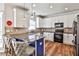 Modern kitchen with granite countertops, white cabinetry, stainless steel appliances, and stylish breakfast bar seating at 705 Chanson Sw Dr, Marietta, GA 30064