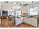 Bright kitchen featuring white cabinets, granite countertops, and stainless steel appliances, seamlessly flowing into an adjacent dining area at 705 Chanson Sw Dr, Marietta, GA 30064