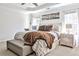 Bright main bedroom with tray ceiling, carpet floors, a decorative bedside table, and upholstered bench at 705 Chanson Sw Dr, Marietta, GA 30064
