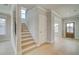 Inviting foyer with staircase, light wood floors, and views into adjacent living areas at 4039 Andover Cir, Mcdonough, GA 30252