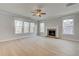 Living room features a brick fireplace, large windows, ceiling fan, and light hardwood floors at 4039 Andover Cir, Mcdonough, GA 30252