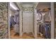 Spacious walk-in closet with ample storage, shelving, and floral wallpaper at 520 Camp Perrin Rd, Lawrenceville, GA 30043