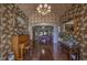 Grand foyer with hardwood floors, decorative wallpaper, chandelier, and ornate furnishings at 520 Camp Perrin Rd, Lawrenceville, GA 30043