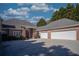 A brick house shows a spacious three-car garage and a well-maintained front yard at 520 Camp Perrin Rd, Lawrenceville, GA 30043