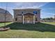 Backyard featuring a covered porch, lush green lawn, and a partial view of the brick home at 249 Chiswick Loop, Stockbridge, GA 30281