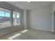 Well-lit room with light hardwood floors and two large windows overlooking the exterior at 249 Chiswick Loop, Stockbridge, GA 30281