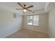 This bedroom boasts a ceiling fan, tray ceiling, neutral carpet, and a large window for natural light at 3348 Terrace Hedge Pl, Dacula, GA 30019