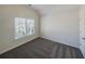 Cozy bedroom featuring a large window, neutral carpeting, and a ceiling fan at 3348 Terrace Hedge Pl, Dacula, GA 30019