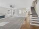 Bright living room featuring a fireplace, ceiling fan, and a staircase with hardwood floors at 3348 Terrace Hedge Pl, Dacula, GA 30019